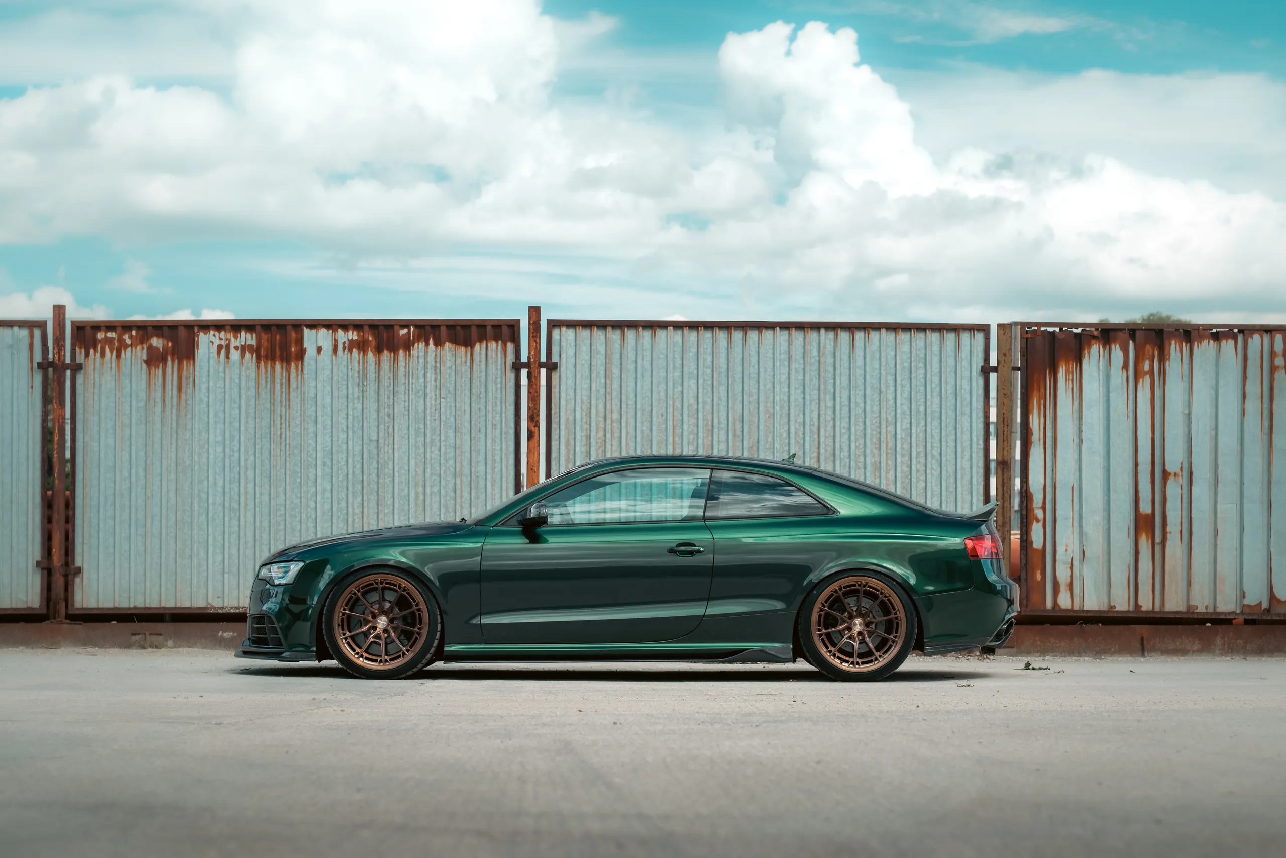 Green Audi RS5, rusty fence