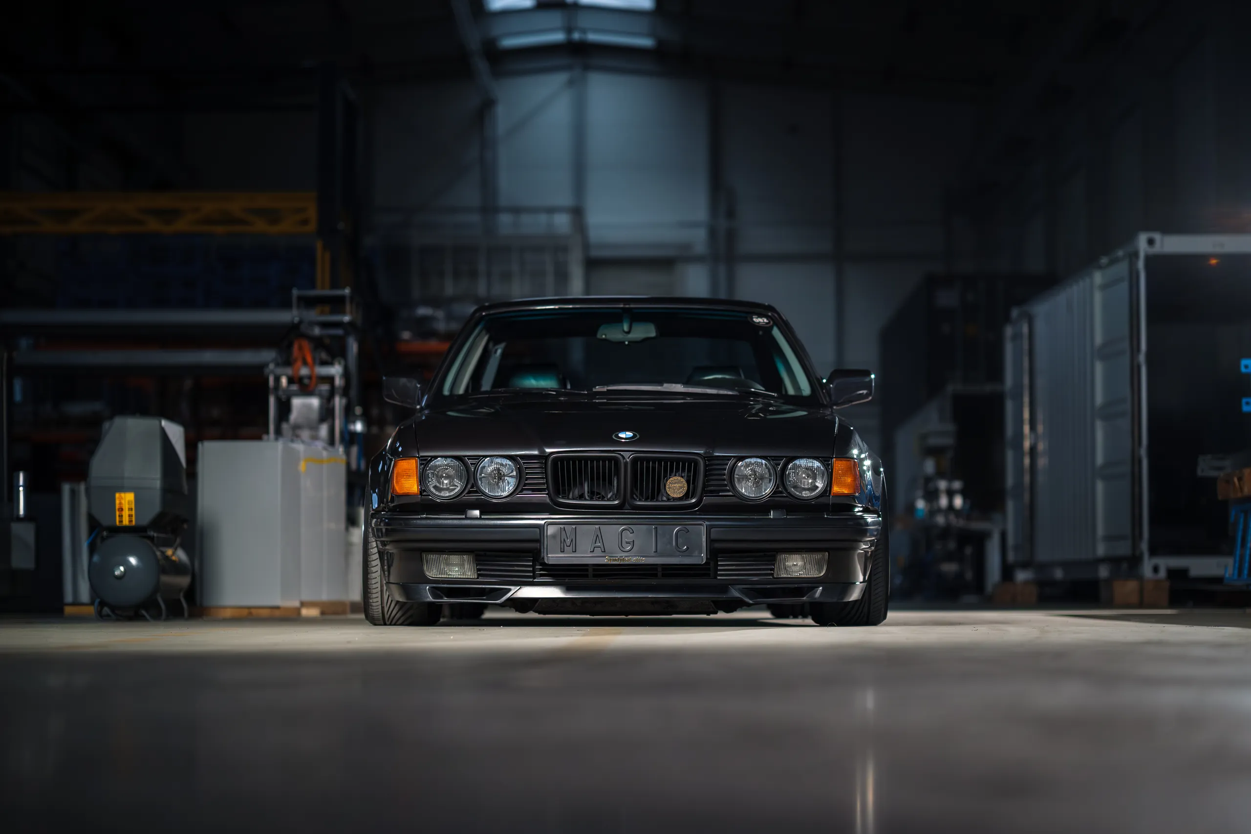 Black BMW E32 in dark garage