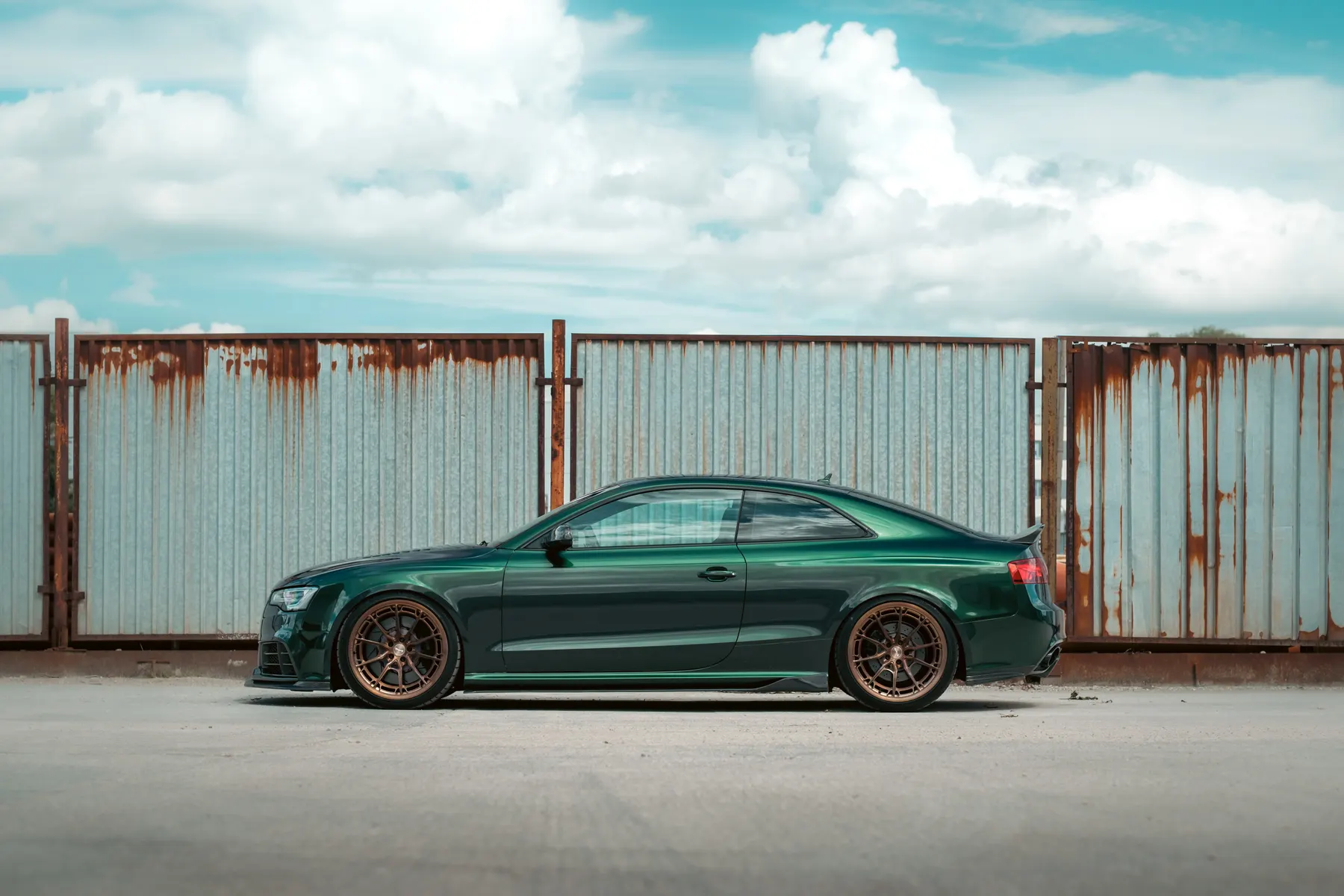 Green Audi RS5, rusty fence