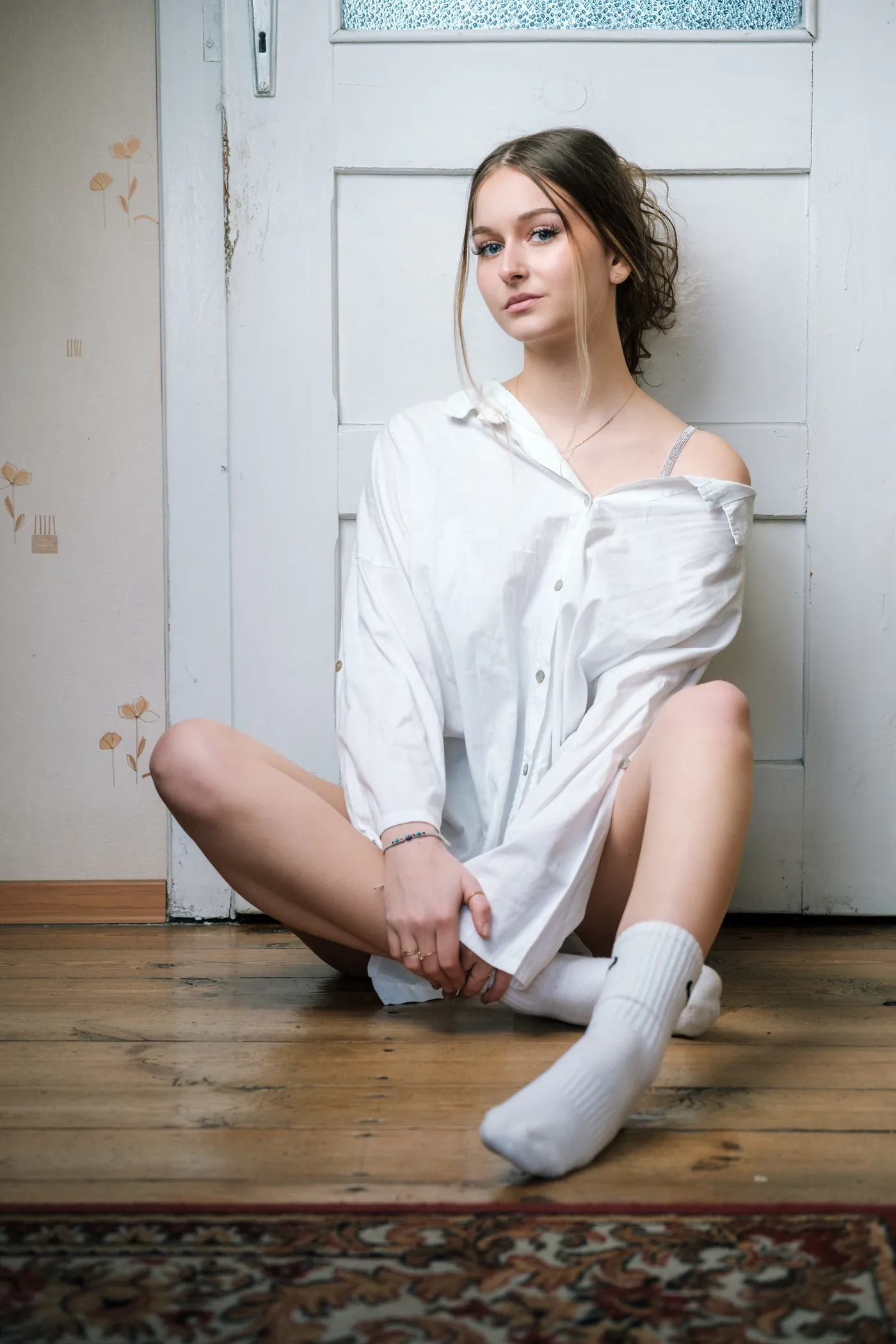 Portrait sitting on wooden floor in white shirt